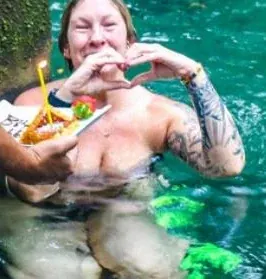 Guest relaxing in the natural pool with tropical fruit