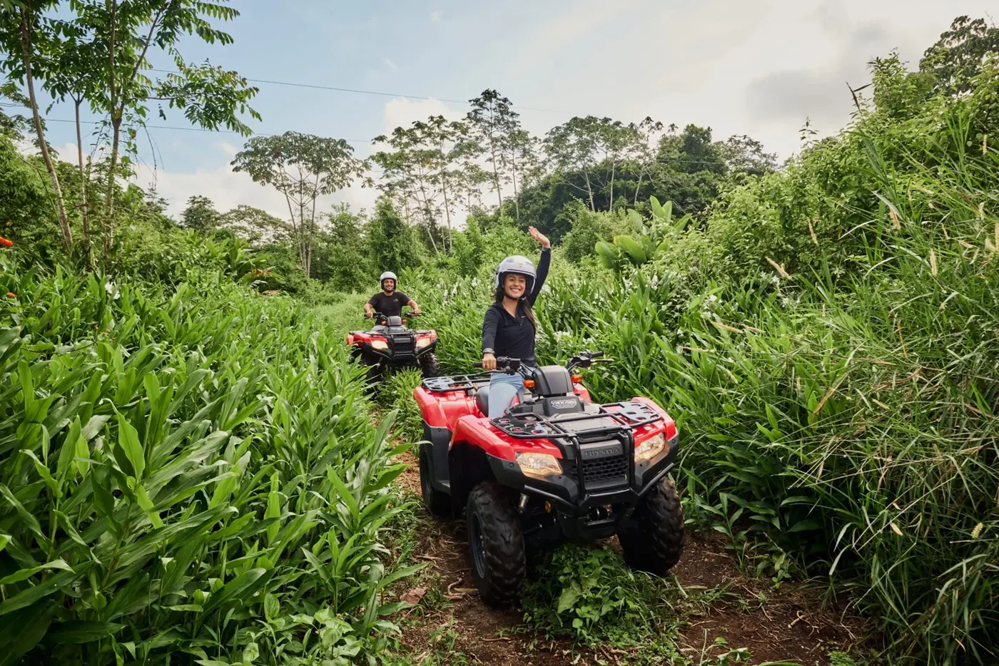 ATV riders on a trail through lush vegetation at Super Quads