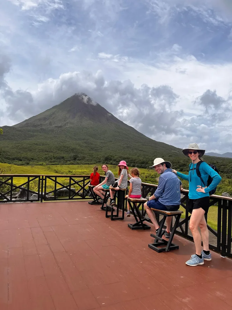 Family at a viewpoint deck facing Arenal Volcano on the Mistico + Arenal 1968 private combo tour