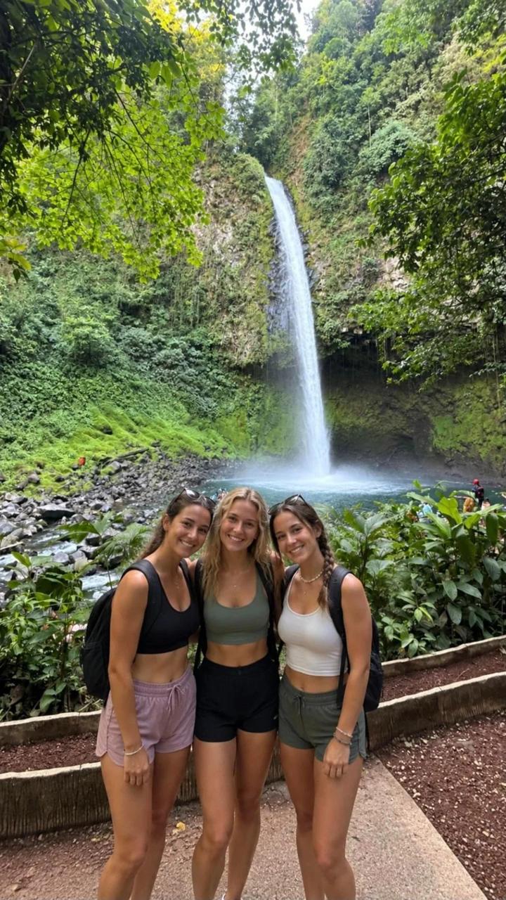 Friends smiling in front of La Fortuna Waterfall, Costa Rica