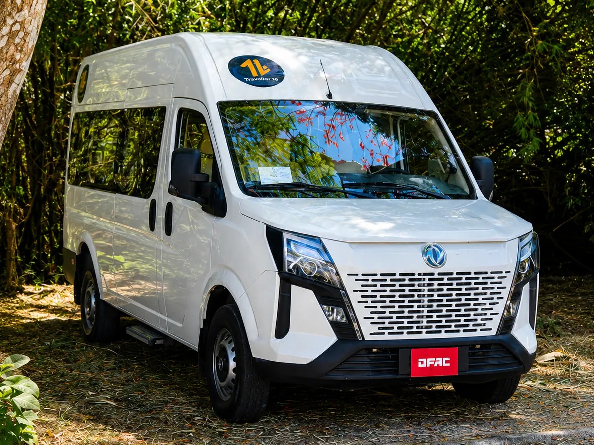 White 16-passenger van parked among trees
