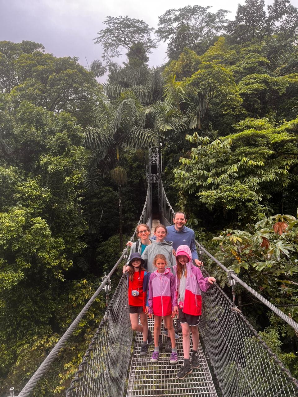 Family on a hanging bridge in the Arenal rainforest canopy